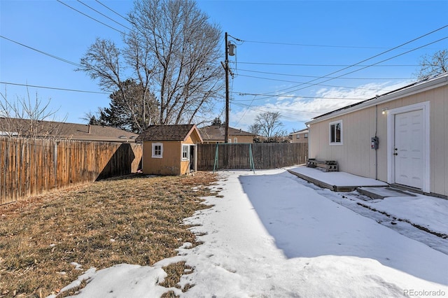 yard layered in snow with a shed