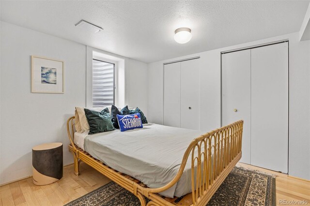 1335 Jasmine St, Denver, CO 80220 - bedroom with two closets, wood finished floors, and a textured ceiling