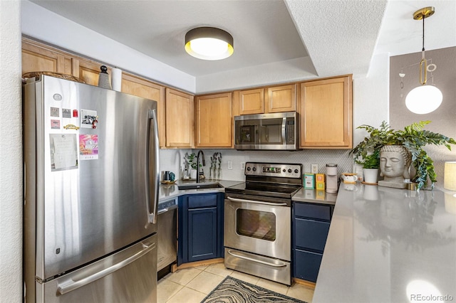 kitchen with hanging light fixtures, a sink, stainless steel appliances, light tile patterned flooring, and blue cabinetry