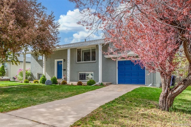bi-level home with a garage, concrete driveway, a front lawn, and brick siding