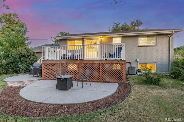3841 W Quinn Pl, Denver, CO 80236 - rear view of house featuring a patio area, an outdoor fire pit, brick siding, a deck, and a lawn
