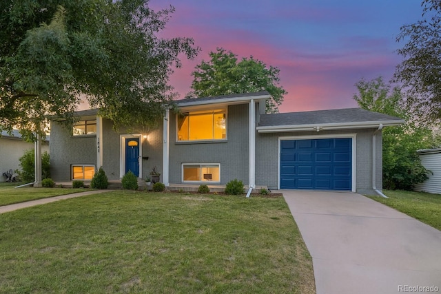 3841 W Quinn Pl, Denver, CO 80236 - view of front of home featuring a garage, driveway, a front yard, and brick siding