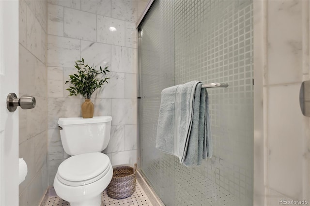 full bathroom featuring tile walls, toilet, and a stall shower