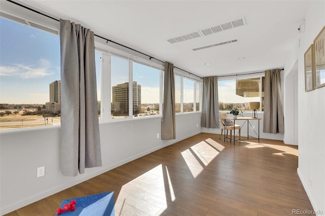 sunroom featuring visible vents and a city view