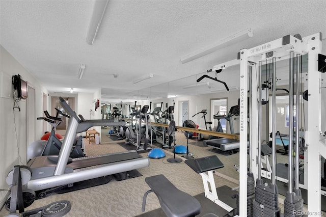 exercise room featuring carpet floors and a textured ceiling