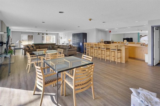 dining room with light wood-style flooring and a textured ceiling