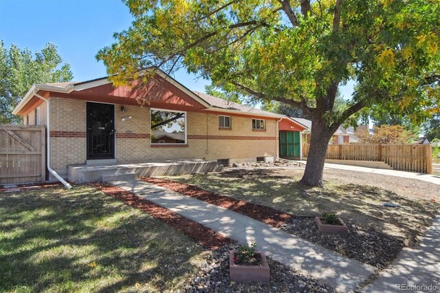 7886 Cyd Dr, Denver, CO 80221 - view of front of home with a front yard, fence, and brick siding