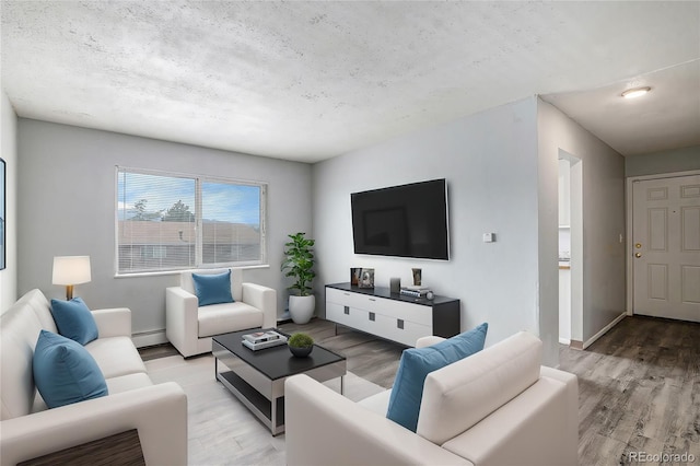 living room with light wood-type flooring, a textured ceiling, and baseboard heating