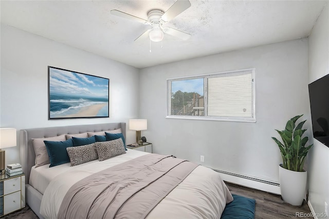 bedroom featuring baseboard heating, ceiling fan, and dark wood-type flooring