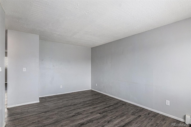 unfurnished room featuring dark wood-type flooring and a textured ceiling