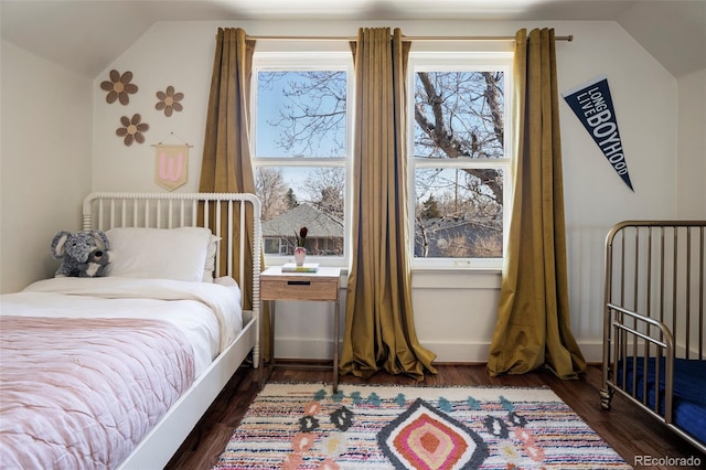 bedroom with dark wood-type flooring and lofted ceiling