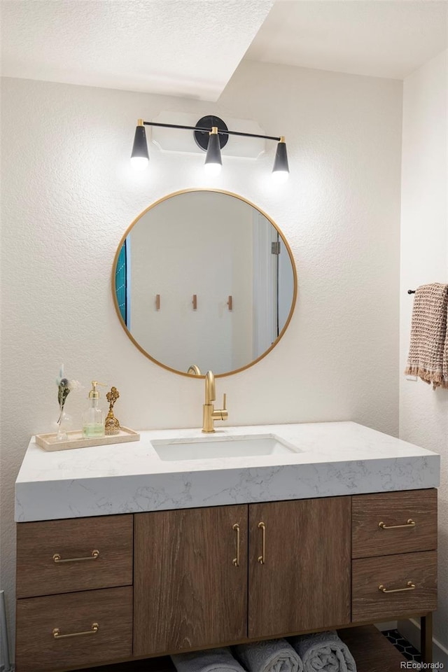 bathroom featuring a textured wall and vanity