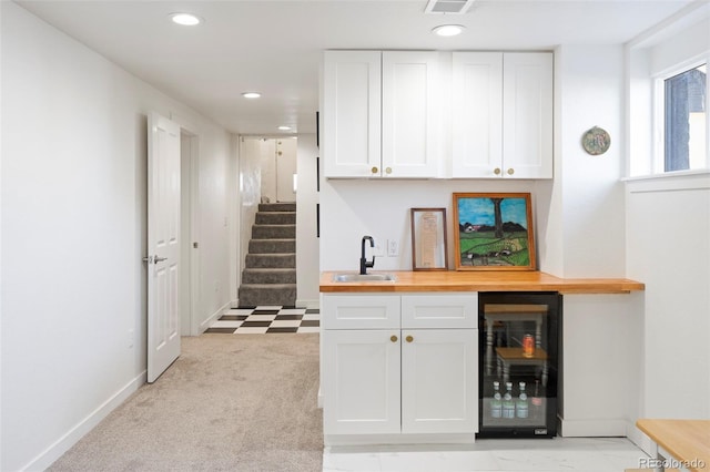 bar featuring wine cooler, a sink, wet bar, and recessed lighting