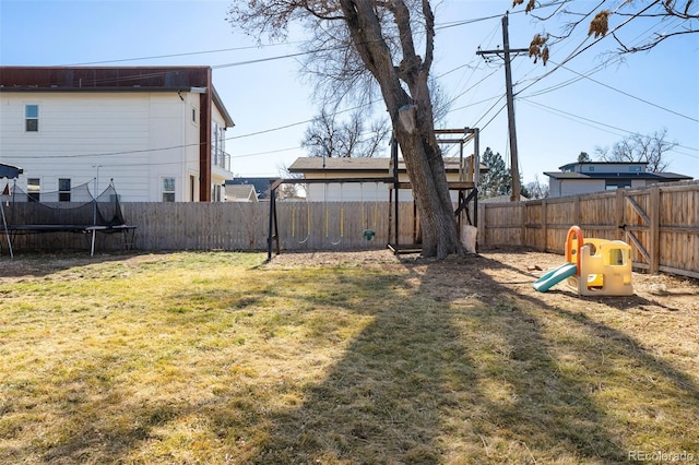 view of yard with a trampoline and a fenced backyard