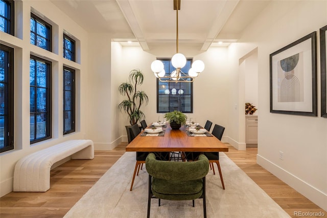 dining space with baseboards, light wood-style flooring, a chandelier, and beam ceiling