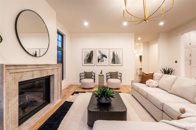 living area featuring light wood-type flooring, a fireplace, baseboards, and recessed lighting