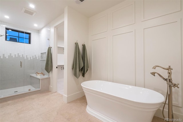 full bathroom featuring recessed lighting, visible vents, a freestanding bath, a stall shower, and baseboards