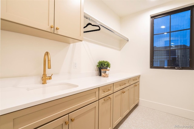 interior space with light countertops, a sink, and baseboards