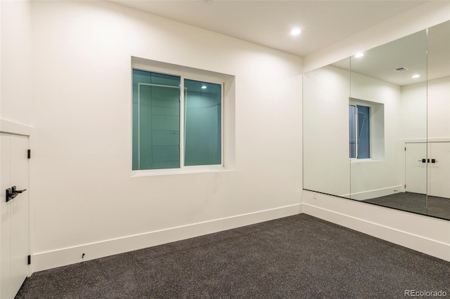 empty room featuring baseboards and recessed lighting