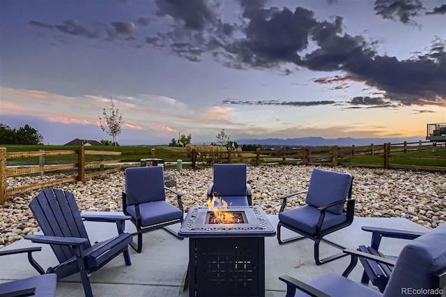 38 Morgan Cir, Erie, CO 80516 - patio terrace at dusk featuring a fire pit, a patio area, and a mountain view