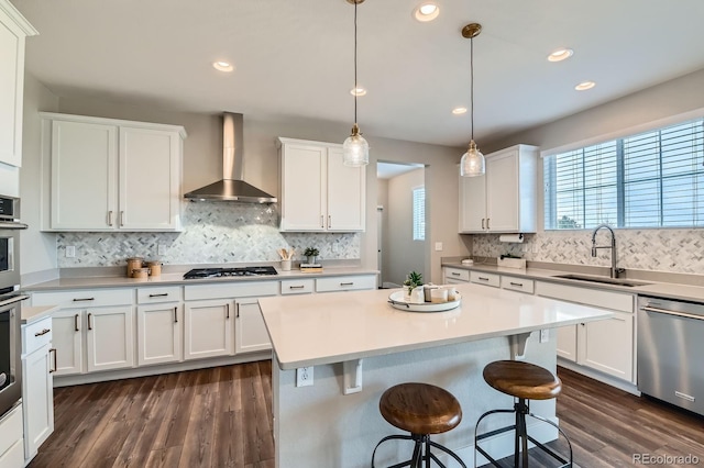 38 Morgan Cir, Erie, CO 80516 - kitchen featuring wall chimney exhaust hood, a sink, appliances with stainless steel finishes, white cabinets, and decorative backsplash