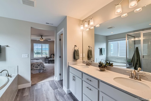 38 Morgan Cir, Erie, CO 80516 - ensuite bathroom with wood finished floors, double vanity, a garden tub, a shower stall, and ceiling fan