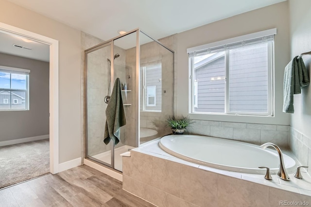 38 Morgan Cir, Erie, CO 80516 - bathroom with a garden tub, a stall shower, wood finished floors, and baseboards