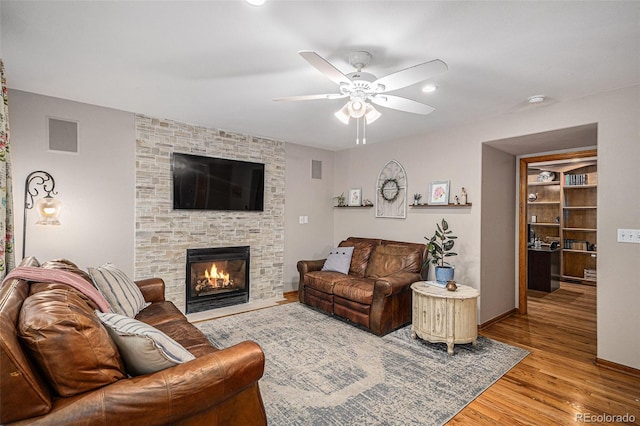 9640 Moss Rose Cir, Highlands Ranch, CO 80129 - living area featuring ceiling fan, light wood-type flooring, and a fireplace