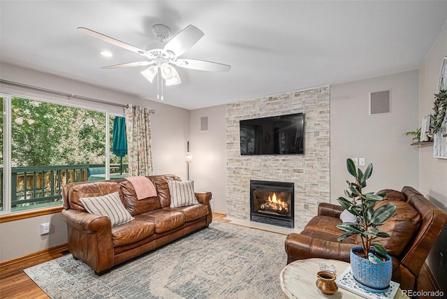 9640 Moss Rose Cir, Highlands Ranch, CO 80129 - living area featuring ceiling fan, wood finished floors, and a stone fireplace
