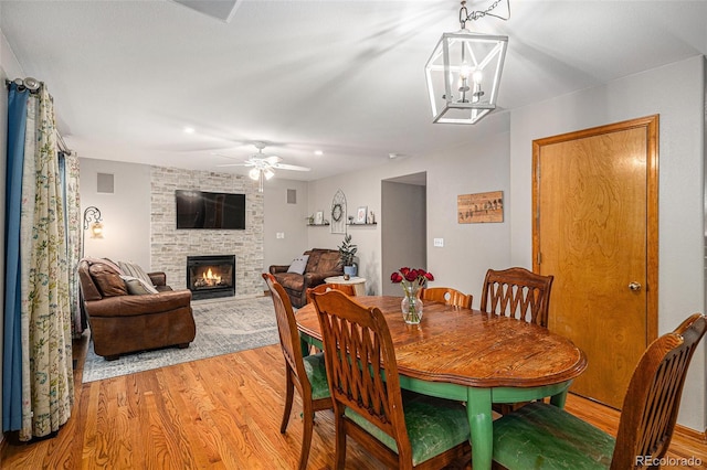 9640 Moss Rose Cir, Highlands Ranch, CO 80129 - dining area with light wood-style flooring, a fireplace, and ceiling fan