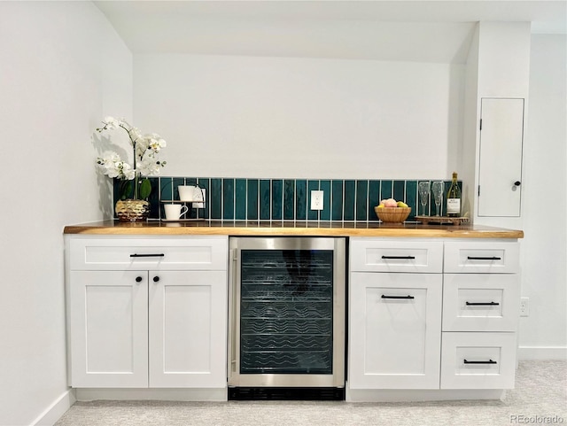 bar with white cabinets, beverage cooler, and backsplash