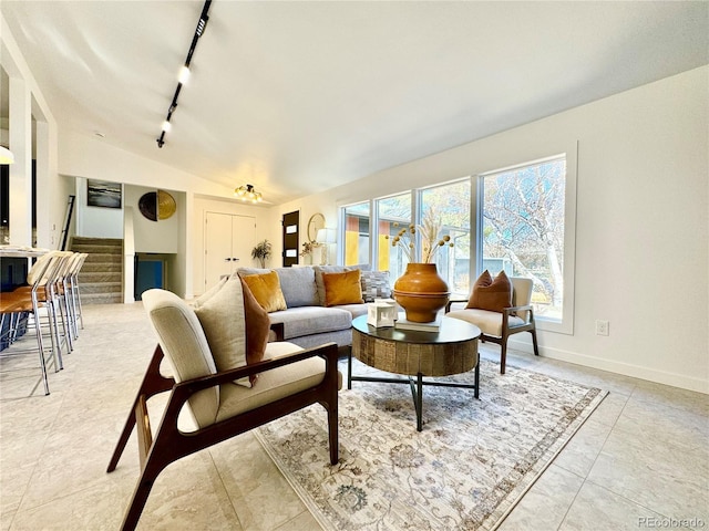 living room featuring rail lighting and vaulted ceiling