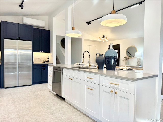 kitchen featuring a wall mounted air conditioner, pendant lighting, sink, white cabinets, and stainless steel appliances