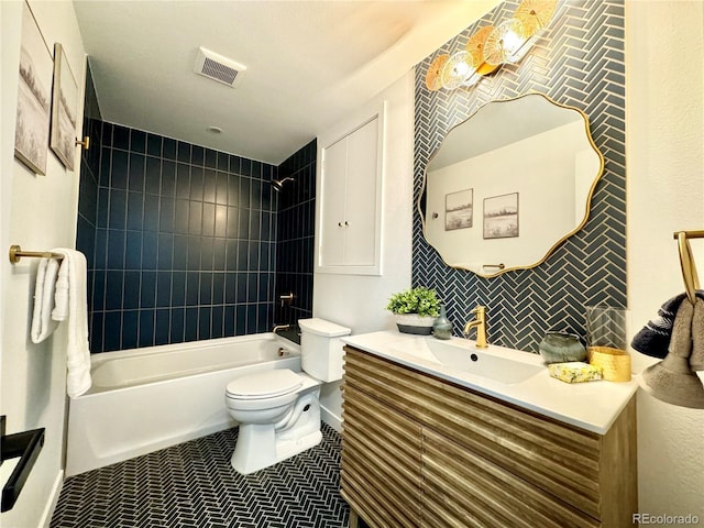 full bathroom featuring tiled shower / bath, vanity, toilet, and tile patterned flooring