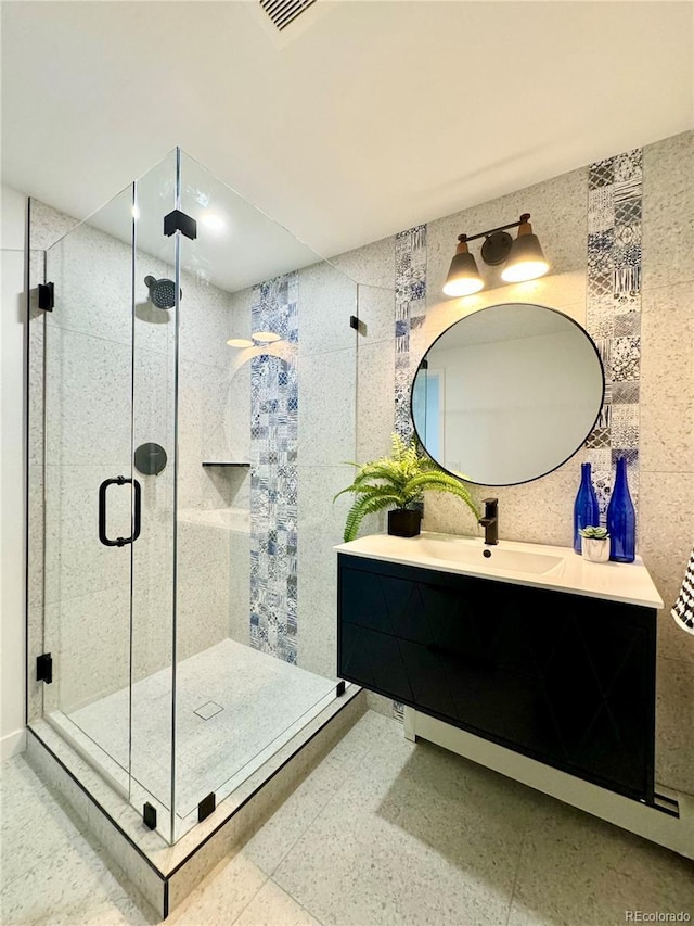 bathroom with a shower with door and vanity