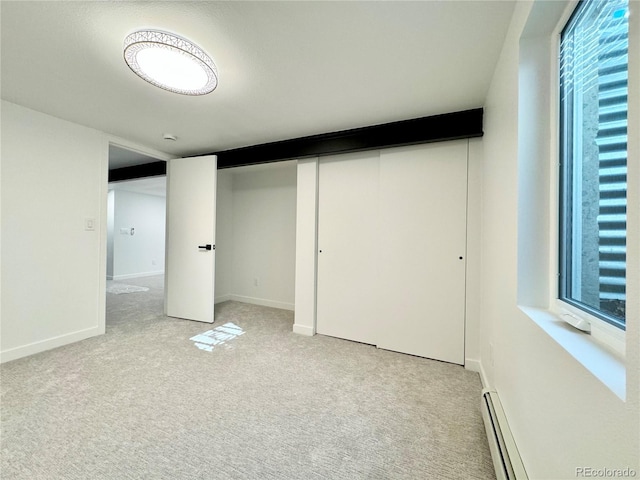 interior space with light carpet and baseboard heating