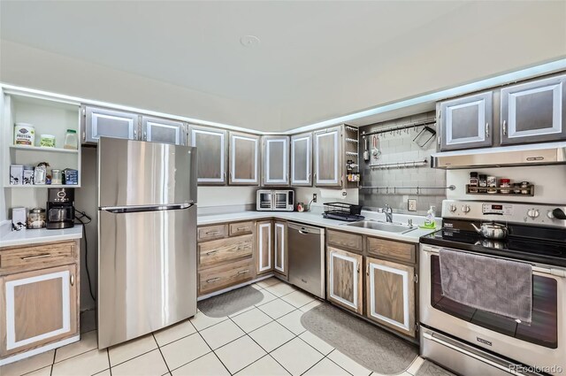 kitchen featuring sink, decorative backsplash, light tile patterned floors, exhaust hood, and appliances with stainless steel finishes