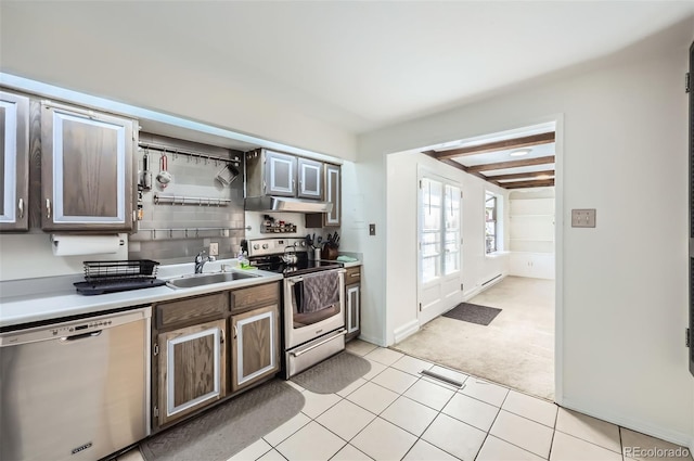 kitchen with dark brown cabinetry, sink, light tile patterned flooring, and appliances with stainless steel finishes