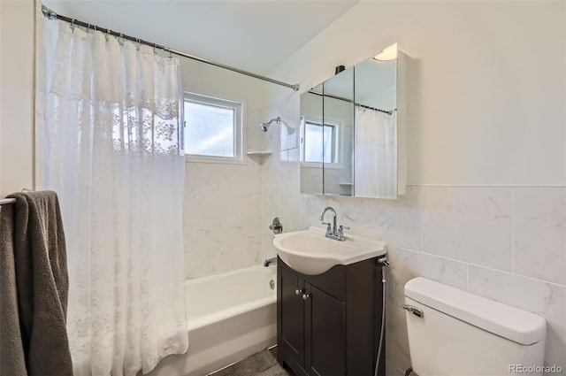 full bathroom with shower / bath combo, vanity, toilet, and tile walls