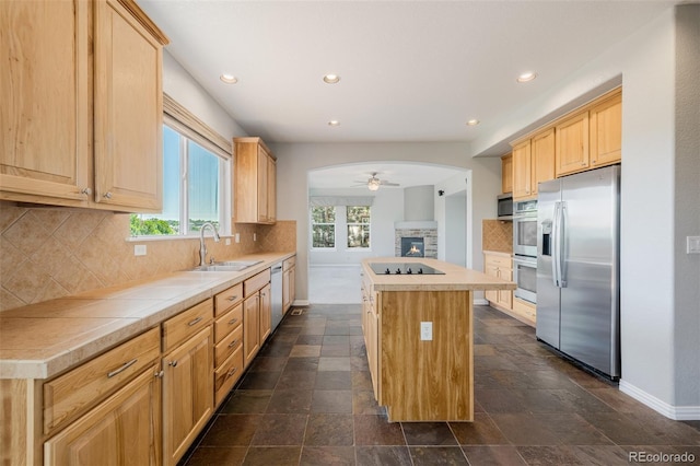 3126 Aspen Creek Dr, Highlands Ranch, CO 80129 - kitchen with stainless steel appliances, a stone fireplace, baseboards, ceiling fan, and a kitchen island