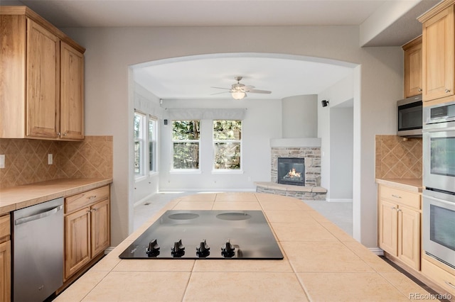 3126 Aspen Creek Dr, Highlands Ranch, CO 80129 - kitchen with appliances with stainless steel finishes, tile countertops, arched walkways, open floor plan, and tile patterned floors