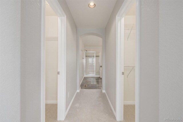 3126 Aspen Creek Dr, Highlands Ranch, CO 80129 - corridor featuring arched walkways, baseboards, recessed lighting, and light colored carpet