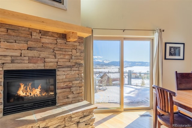 doorway featuring a fireplace, a mountain view, visible vents, and wood finished floors