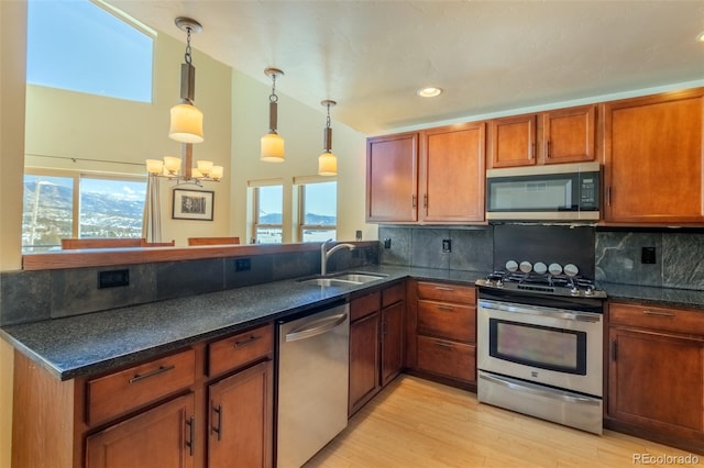 kitchen featuring stainless steel appliances, decorative backsplash, light wood-style floors, a sink, and plenty of natural light