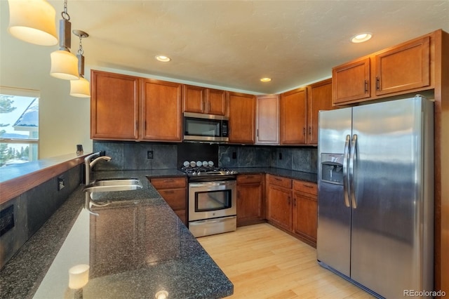 kitchen featuring stainless steel appliances, brown cabinetry, a sink, and backsplash