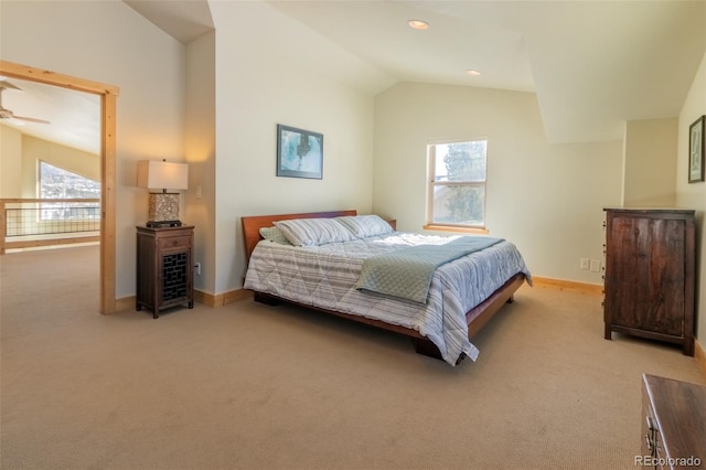 bedroom with vaulted ceiling, multiple windows, light carpet, and baseboards