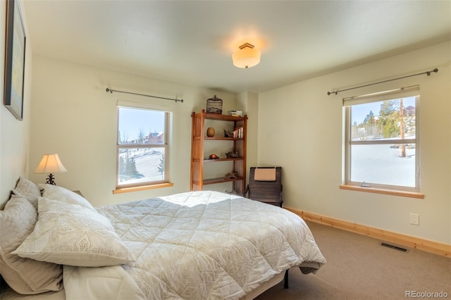 carpeted bedroom featuring visible vents and baseboards