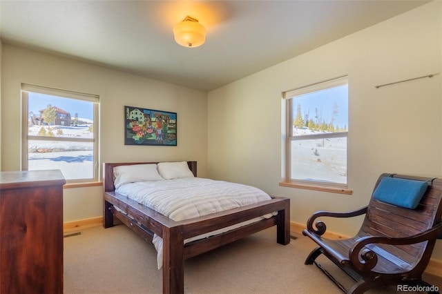 bedroom featuring light carpet, visible vents, and baseboards