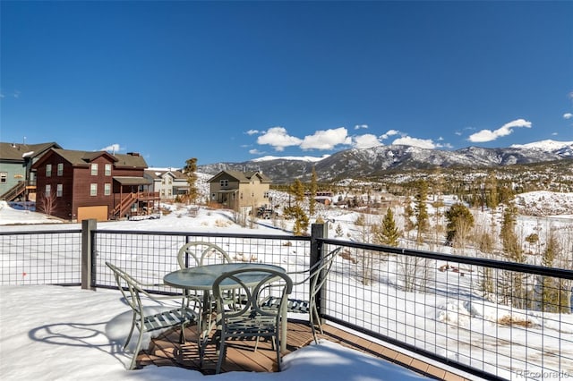 snow covered deck with a residential view and a mountain view