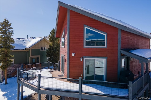 snow covered rear of property with a patio